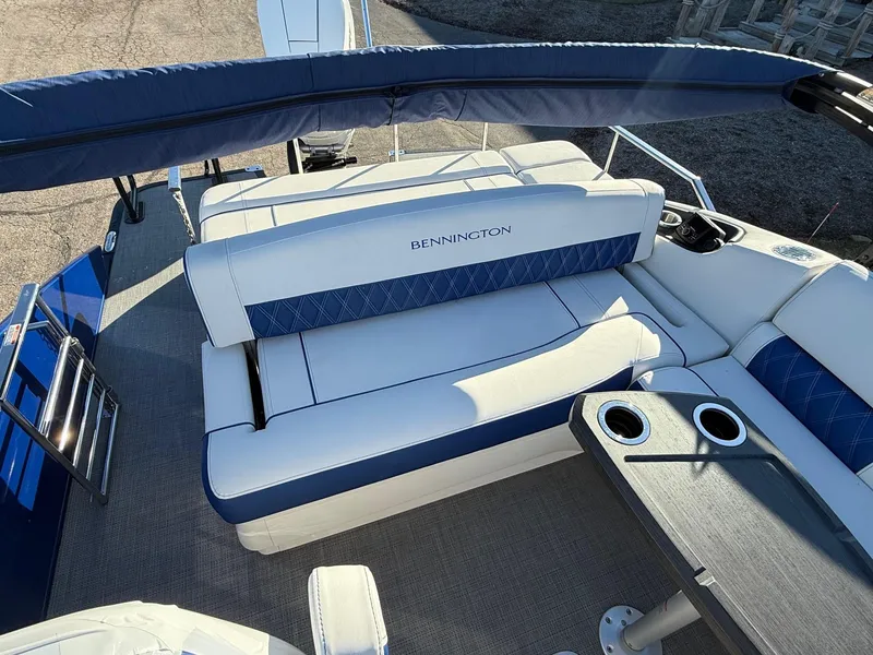 Slide: The Image of 2024 Bennington RX Sport Line boat interior with blue and white seating and cup holders. - 13