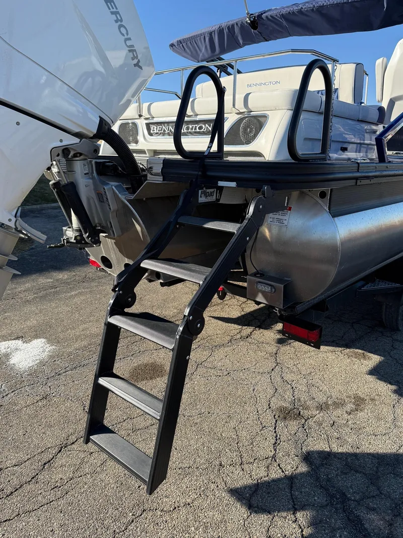 Slide: The Image of 2024 Bennington RX Sport Line boat with rear ladder and Mercury engine. - 6