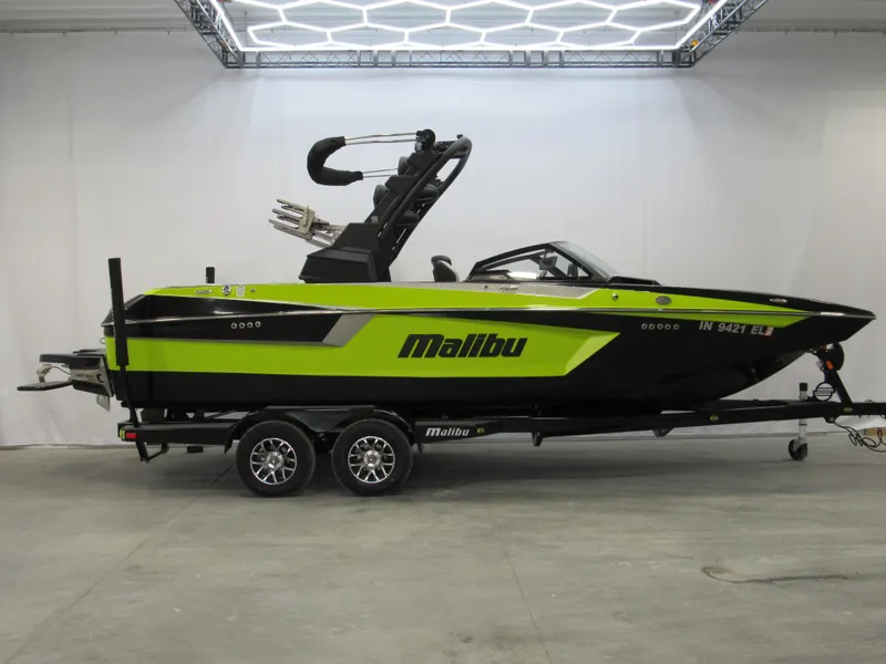 Slide: The Image of 2023 Malibu Wakesetter 23 MXZ boat in vibrant green and black on a trailer. - 0