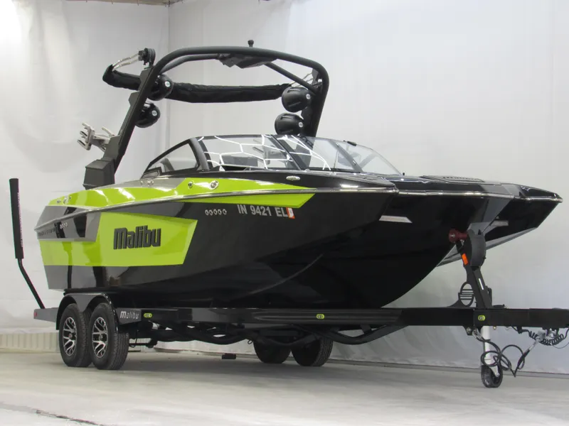 Slide: The Image of 2023 Malibu Wakesetter 23 MXZ boat in black and green on trailer. - 1
