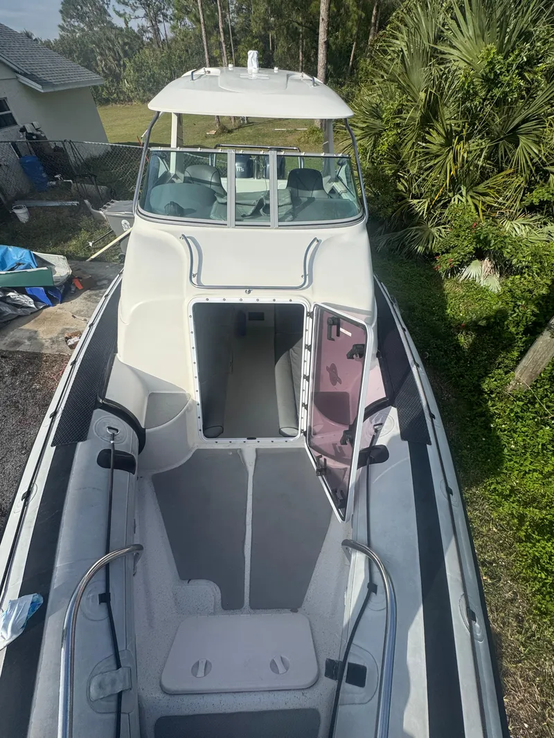 Slide: The Image of 2002 Protector 28 Targa boat with open cabin, docked near greenery. - 11