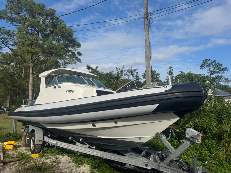 Slide: The Image of 2002 Protector 28 Targa boat on trailer, surrounded by trees and blue sky. - 3