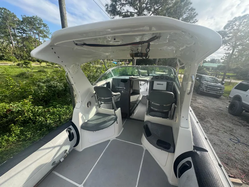 Slide: The Image of 2002 Protector 28 Targa boat interior with seating and canopy, parked outdoors. - 4