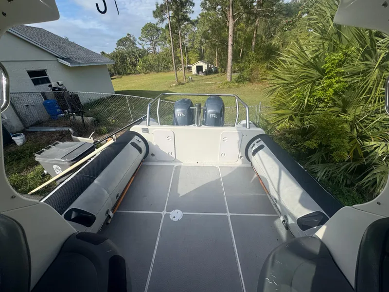 Slide: The Image of 2002 Protector 28 Targa boat deck with twin engines, surrounded by lush greenery. - 9