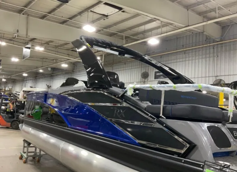 Slide: The Image of 2024 Bennington RX Sport Line pontoon boat in a showroom. - 2