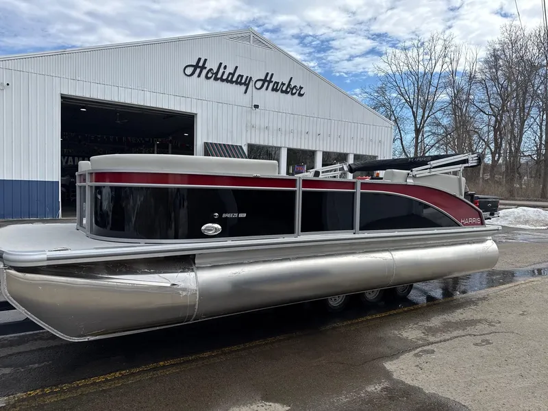 The Image of 2025 Harris Breeze 230 pontoon boat parked outside Holiday Harbor building. - 0