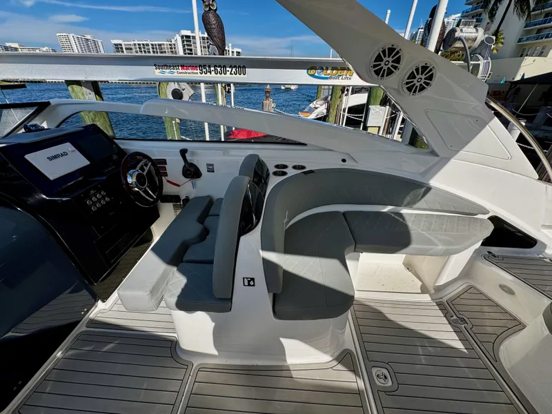 Slide: The Image of 2024 NX Boats 280 Xtreme cockpit with modern seating and controls, docked by the water. - 11