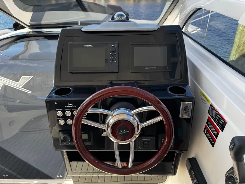 Slide: The Image of 2024 NX Boats 280 Xtreme dashboard with steering wheel and navigation controls. - 14