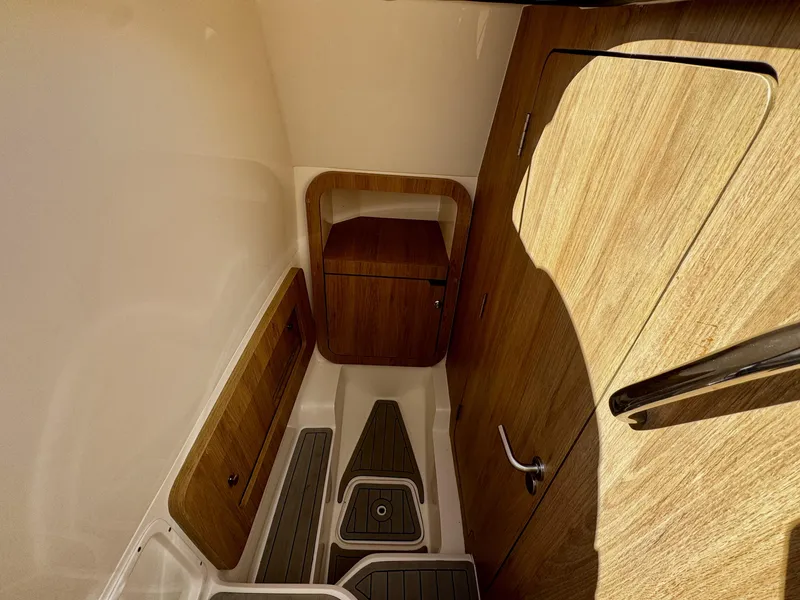 Slide: The Image of 2024 NX Boats 280 Xtreme cabin interior with wood finish and modern design. - 16