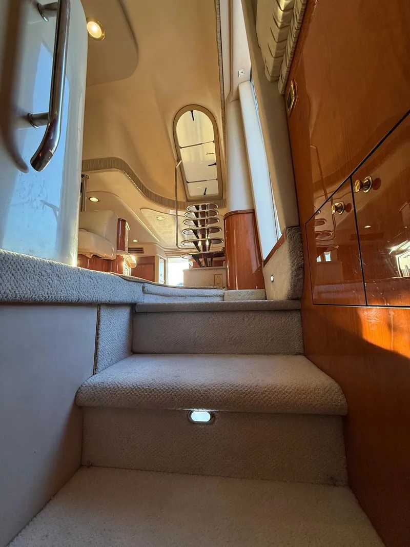 Slide: The Image of Interior view of 2001 Sea Ray 540 Cockpit Motor Yacht, featuring carpeted stairs and wooden cabinetry. - 16