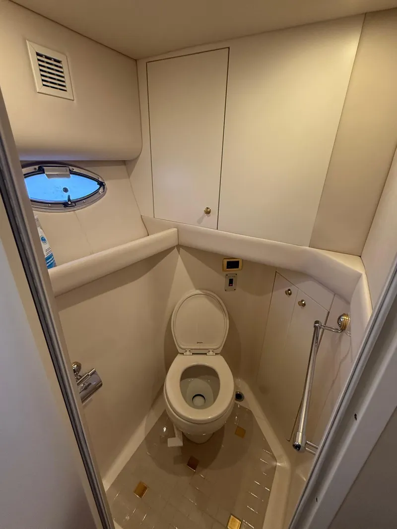 Slide: The Image of Bathroom interior of 2001 Sea Ray 540 Cockpit Motor Yacht, featuring a compact toilet. - 26