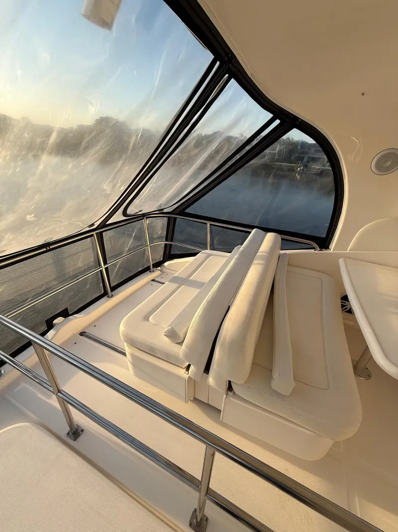 Slide: The Image of 2001 Sea Ray 540 Cockpit Motor Yacht interior with cushioned seating and panoramic windows. - 28