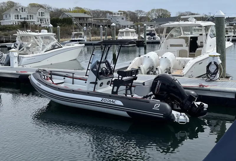 Slide: The Image of 2024 Zodiac Open 6.5 boat docked in a marina with other vessels. - 0