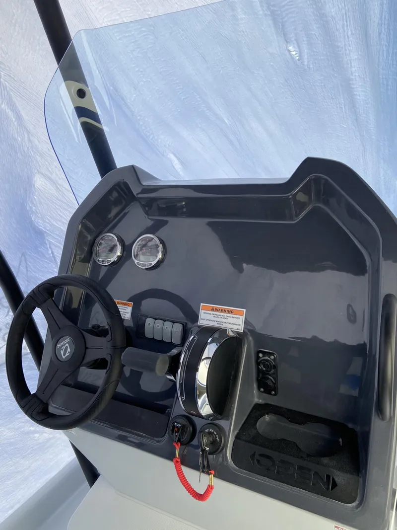 Slide: The Image of 2024 Zodiac Open 6.5 boat dashboard with steering wheel and controls. - 3
