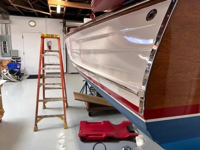 Slide: The Image of 1956 Custom South Coast Boatyard vessel in workshop, ladder nearby, polished hull visible. - 6