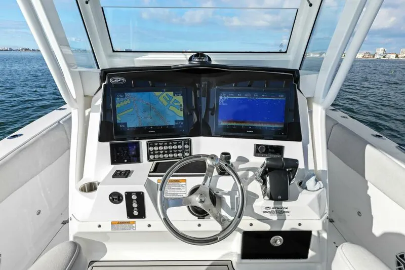 Slide: The Image of 2024 Sea Fox 328 Commander boat dashboard with dual navigation screens on open water. - 11