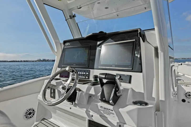 Slide: The Image of 2024 Sea Fox 328 Commander boat dashboard with dual screens and steering wheel. - 12