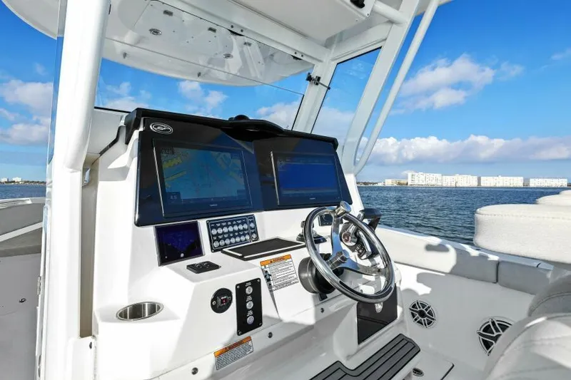 Slide: The Image of 2024 Sea Fox 328 Commander boat dashboard with dual screens and steering wheel. - 2
