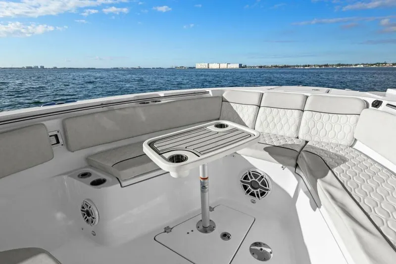 Slide: The Image of 2024 Sea Fox 328 Commander boat interior with seating and table, ocean view. - 22
