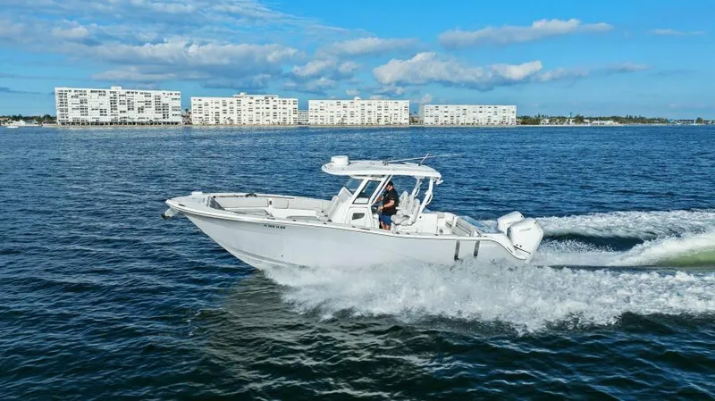 Slide: The Image of 2024 Sea Fox 328 Commander cruising on open water near coastal buildings. - 42