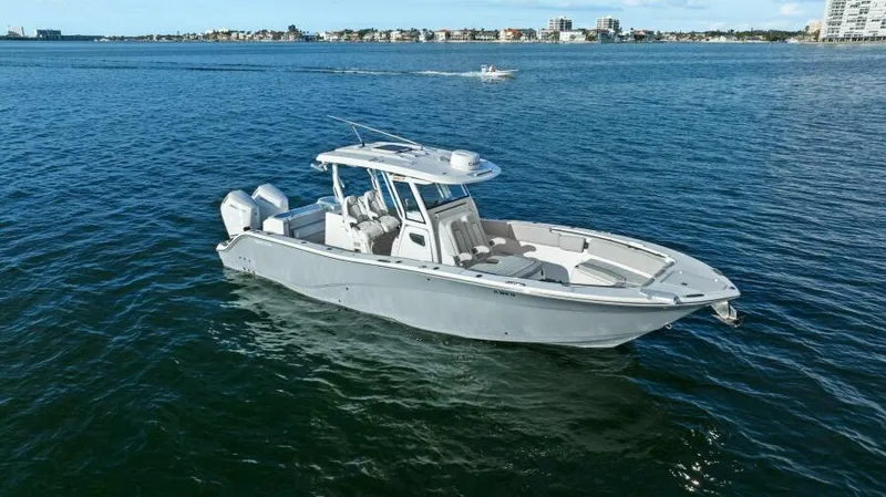 Slide: The Image of 2024 Sea Fox 328 Commander boat on open water, city skyline in background. - 48