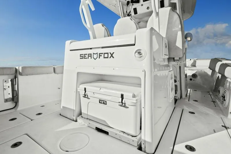 Slide: The Image of 2024 Sea Fox 328 Commander boat deck with Yeti cooler, white interior, and blue sky background. - 9