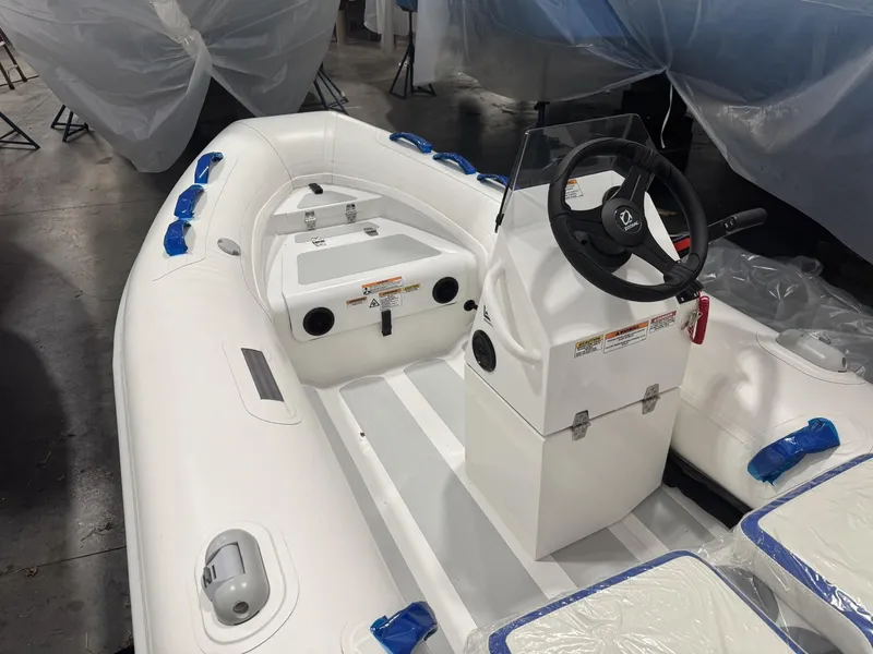 Slide: The Image of 2024 Zodiac Nomad 3.6 RIB Alu inflatable boat with steering console, white interior. - 2