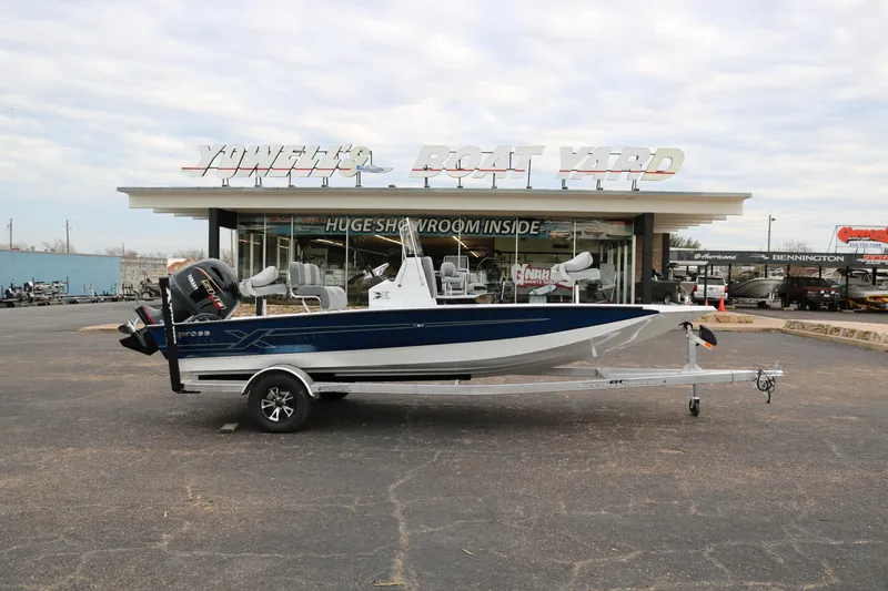 The Image of 2025 Xpress H20B boat on trailer outside dealership showroom. - 0
