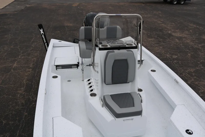 Slide: The Image of 2025 Xpress H20B boat interior with seating and console on a paved surface. - 17