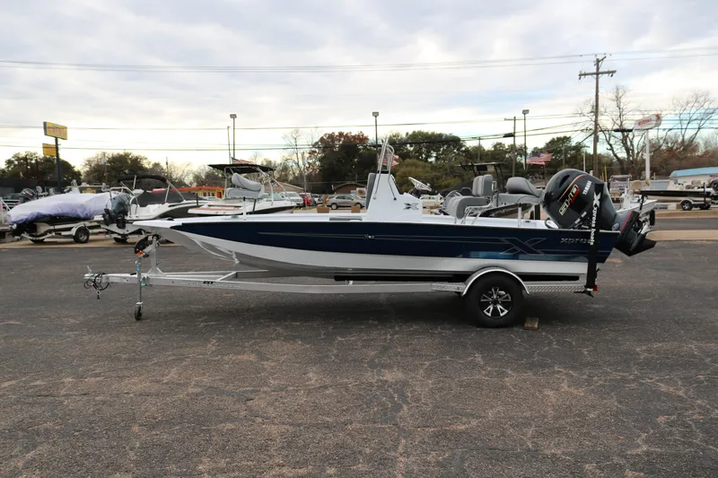 Slide: The Image of 2025 Xpress H20B boat on trailer in parking lot, side view. - 3