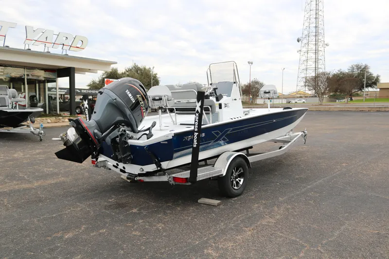 Slide: The Image of 2025 Xpress H20B boat with outboard motor on a trailer in a dealership lot. - 6