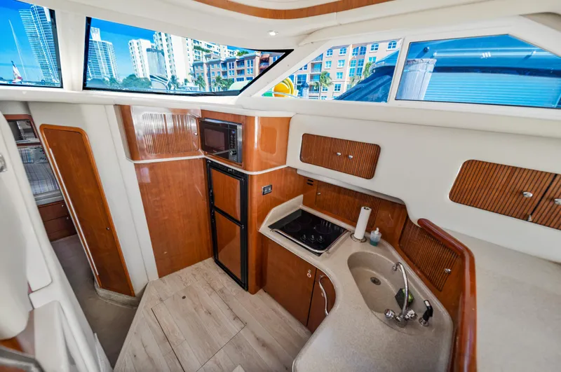 Slide: The Image of Interior of 2003 Sea Ray 400 Sedan Bridge yacht with modern kitchen amenities. - 16