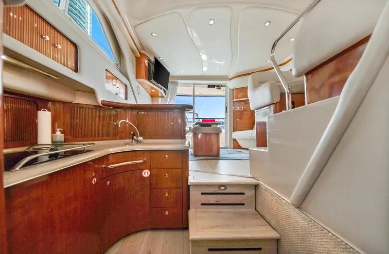 Slide: The Image of Luxurious interior of 2003 Sea Ray 400 Sedan Bridge yacht with modern kitchen and seating. - 18