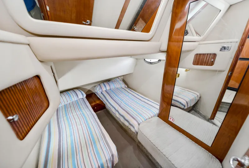 Slide: The Image of 2003 Sea Ray 400 Sedan Bridge cabin with twin beds and wood accents. - 21