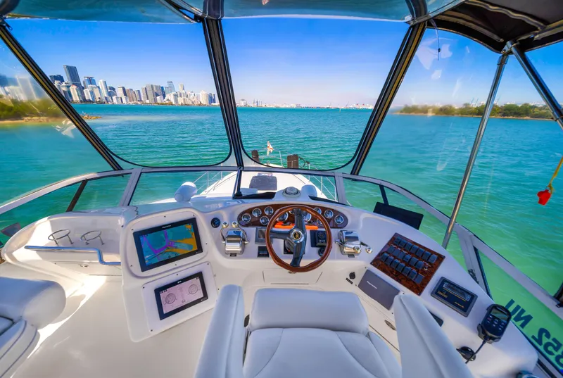 Slide: The Image of Interior view of 2003 Sea Ray 400 Sedan Bridge yacht cockpit with city skyline. - 6