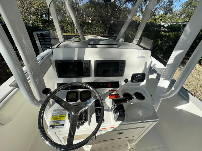Slide: The Image of 2015 Sea Hunt Ultra 234 boat console with steering wheel and navigation screens. - 10