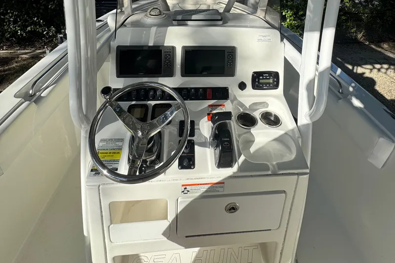 Slide: The Image of 2015 Sea Hunt Ultra 234 boat console with steering wheel and navigation controls. - 12