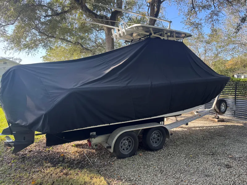 Slide: The Image of 2015 Sea Hunt Ultra 234 boat covered on trailer, parked outdoors. - 16