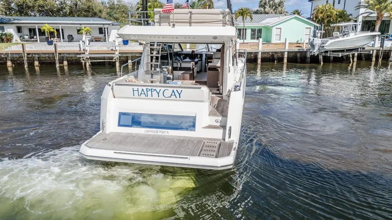 Slide: The Image of Prestige 520 Flybridge 2021 yacht "Happy Cay" cruising near waterfront homes. - 11