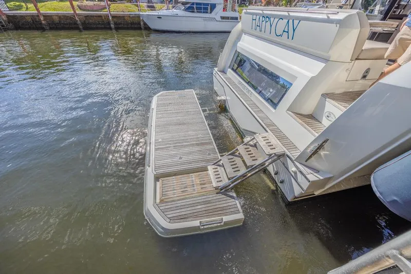 Slide: The Image of Prestige 520 Flybridge 2021 yacht with extended swim platform on calm water. - 16
