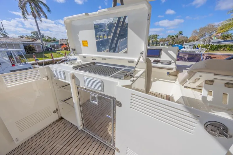 Slide: The Image of Prestige 520 Flybridge 2021 yacht deck with outdoor kitchen and seating area. - 28