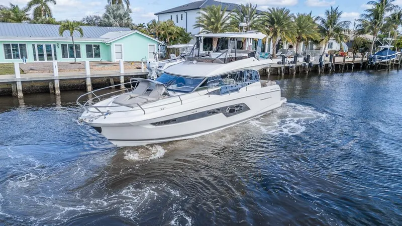 Slide: The Image of Prestige 520 Flybridge 2021 yacht cruising near waterfront homes. - 3