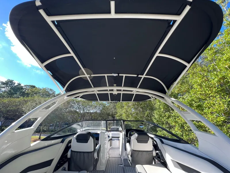 Slide: The Image of 2020 Yamaha Boats 242 Limited SE interior with canopy, showcasing sleek seating and modern design. - 15