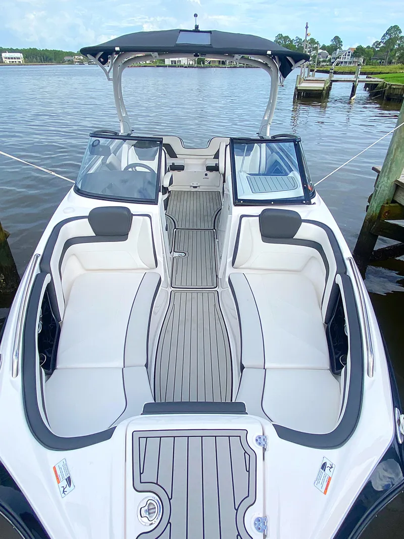Slide: The Image of 2020 Yamaha Boats 242 Limited SE on calm water, showcasing spacious seating and sleek design. - 18