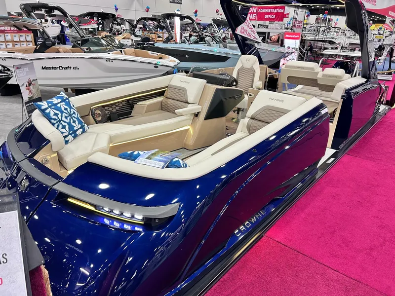Slide: The Image of 2025 Harris Crowne SL 250 luxury pontoon boat displayed indoors on pink carpet. - 6