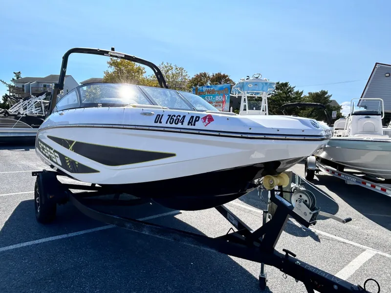 Slide: The Image of 2024 Scarab 195 ID boat on trailer in parking lot. - 1