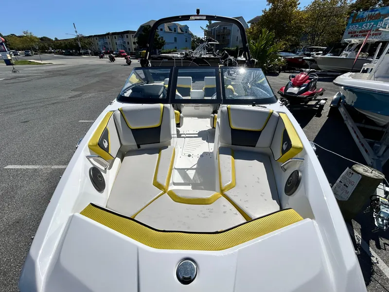 Slide: The Image of 2024 Scarab 195 ID boat with yellow accents, parked outdoors. - 12