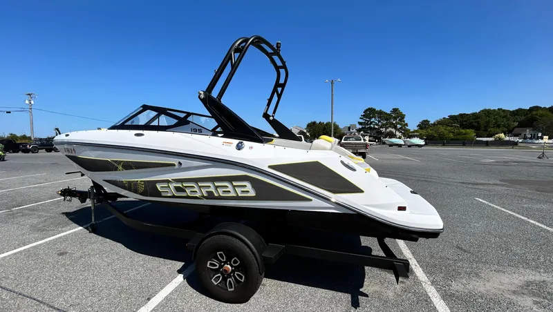 Slide: The Image of 2024 Scarab 195 ID boat on trailer in parking lot, sunny day. - 3