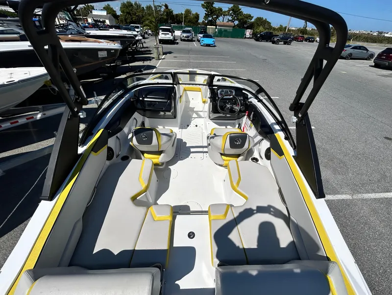 Slide: The Image of 2024 Scarab 195 ID boat interior with modern seating and dashboard in a parking lot. - 4