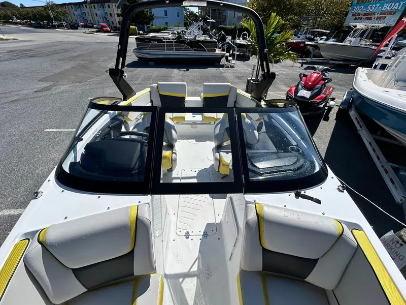 Slide: The Image of 2024 Scarab 195 ID boat with sleek design and spacious seating in a marina setting. - 5